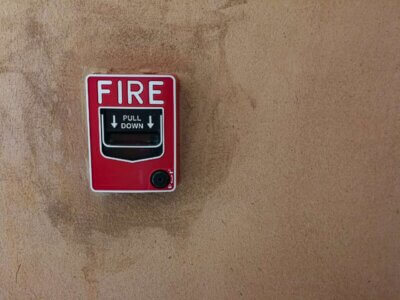 fire break glass alarm switch on a concrete wall